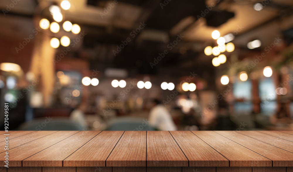 Empty wooden table top with lights bokeh on blur restaurant background.
Empty wooden table top with lights bokeh on blur restaurant background.