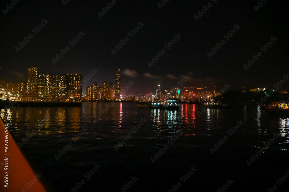 Fototapeta premium The night view of Hong Kong Island from the Kowloon. Hong Kong cityscape and seascape at night. Nature and city scene.