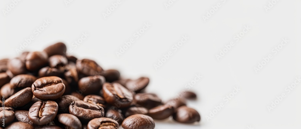  A heap of roasted coffee beans atop a pristine white table, adjacent to an untouched mound of unpeeled beans