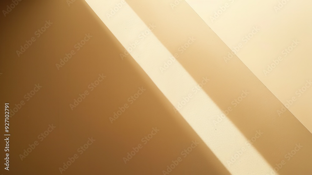 Sunlight streams through a window, casting a diagonal beam of light across a beige wall. The light creates a contrast with the darker wall, highlighting the texture of the surface. Sunlight streams through a window, casting a diagonal beam of light across a beige wall. The light creates a contrast with the darker wall, highlighting the texture of the surface.