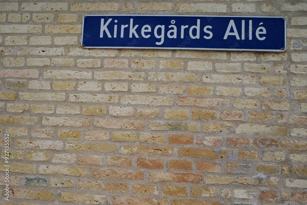 Wall with street name sign in Christianfeld. Kirkegårds Allé is Danish and means Cementery Avenue Wall with street name sign in Christianfeld. Kirkegårds Allé is Danish and means Cementery Avenue