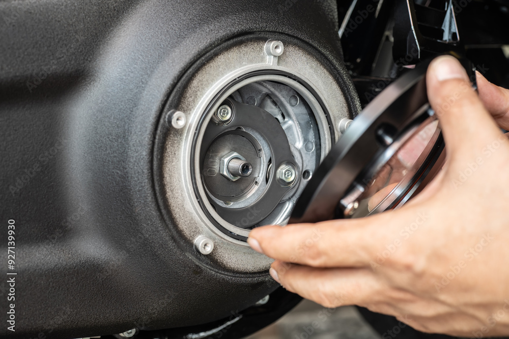 Motorcycle mechanic open cover engine and check the condition clutch system of motorcycle in garage, repair and maintenance concept.selective focus