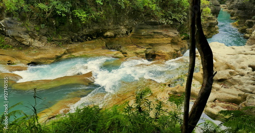 malerischer, Auslauf  des Wasserfalls Tanggedu auf der Insel Sumba in Indonesien zwischen Felsen und vor grünem Wald