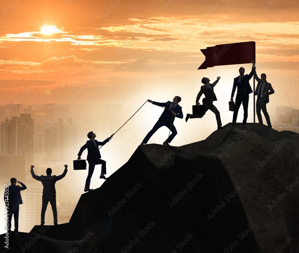 Concept of teamwork with team climbing mountain top