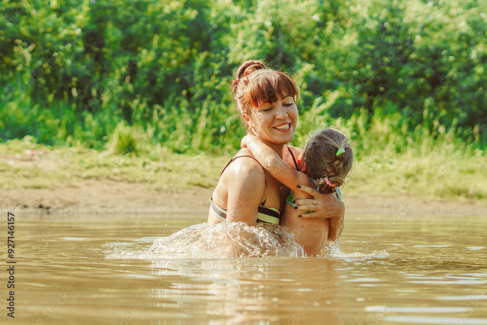 mom and child swim in the river mom and child swim in the river