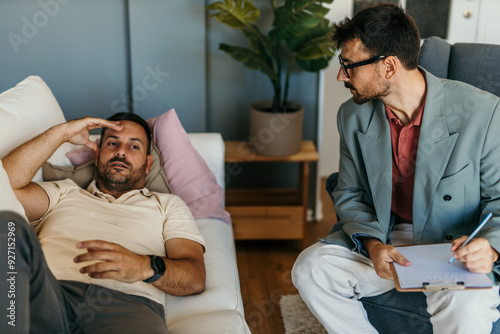 A depressed man is having issues and sharing them with a therapist. Mental heath awareness day concept