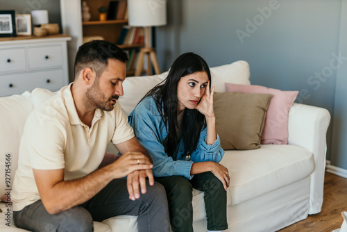 Fight, divorce and depression with couple on sofa for conflict, therapy and mental health or marriage counseling photo