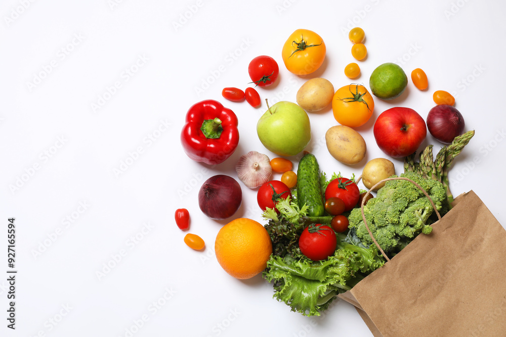 Delivery of vegetarian products. Bag with different vegetables and fruits on white background, top view Delivery of vegetarian products. Bag with different vegetables and fruits on white background, top view