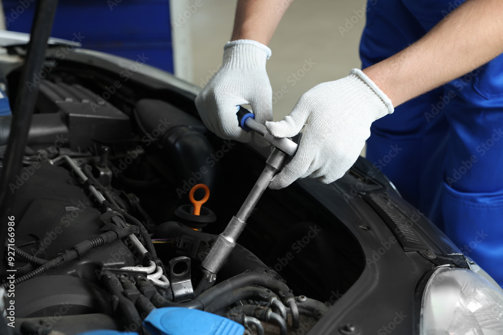 Auto mechanic fixing car at automobile repair shop, closeup Auto mechanic fixing car at automobile repair shop, closeup