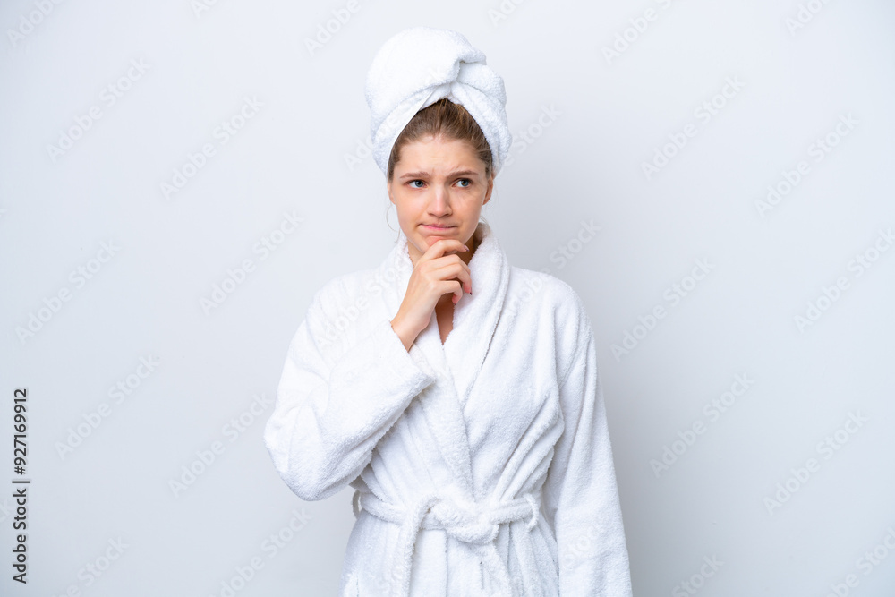 Teenager Russian girl in a bathrobe isolated on white background having doubts and thinking Teenager Russian girl in a bathrobe isolated on white background having doubts and thinking
