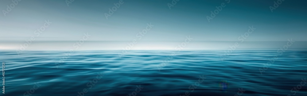 A wide shot of a calm ocean surface under a cloudy sky. The sun is rising in the distance, casting a soft light on the water. The waves are gently rolling, creating a sense of peace and serenity. A wide shot of a calm ocean surface under a cloudy sky. The sun is rising in the distance, casting a soft light on the water. The waves are gently rolling, creating a sense of peace and serenity.
