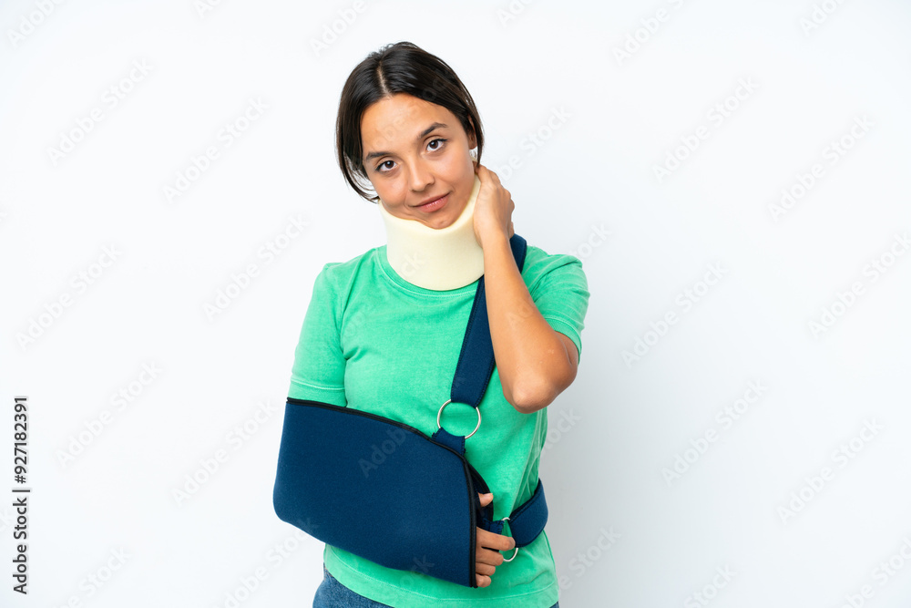 Young hispanic woman wearing a neck brace and sling isolated on white background laughing