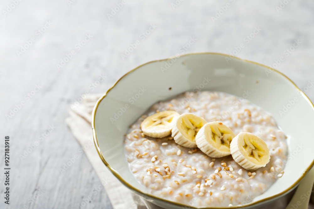 Plate of porridge with slices of bananas, sesame, and a banana. oatmeal healthy bowl concept. a breakfast of porridge, bananas, sesame, and eggs. a breakfast of porridge, a bananas, sesame, and. Plate of porridge with slices of bananas, sesame, and a banana. oatmeal healthy bowl concept. a breakfast of porridge, bananas, sesame, and eggs. a breakfast of porridge, a bananas, sesame, and.