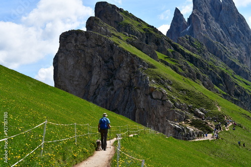 Obraz na płótnie Mann und sein Lagotto Romagnolo Hund wandern auf Seceda in Südtirol w salonie