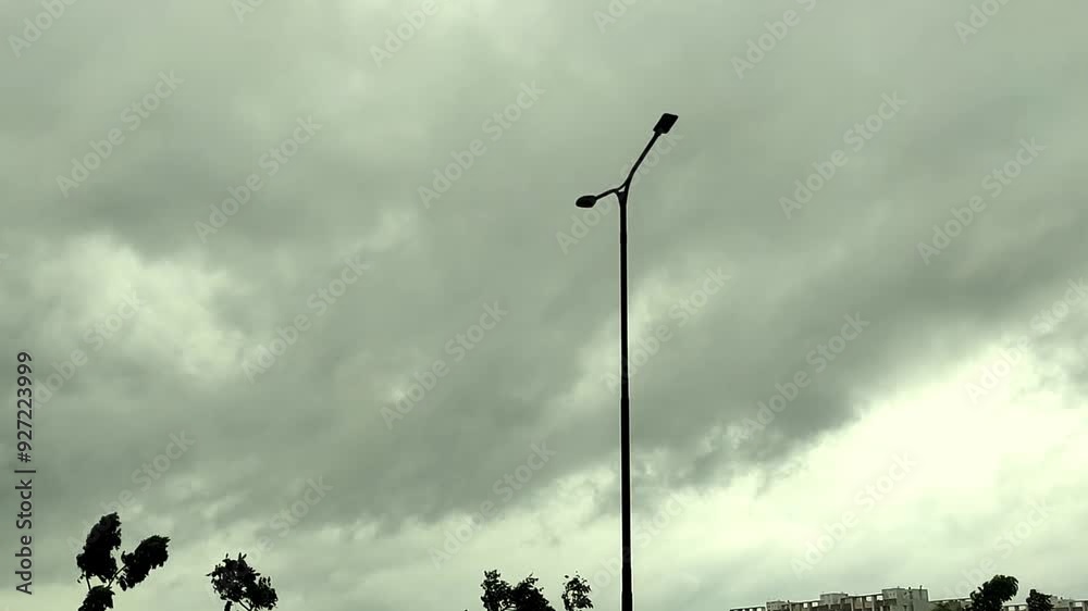Lamp post against Thick Black Clouds forming Sky Lamp post against Thick Black Clouds forming Sky