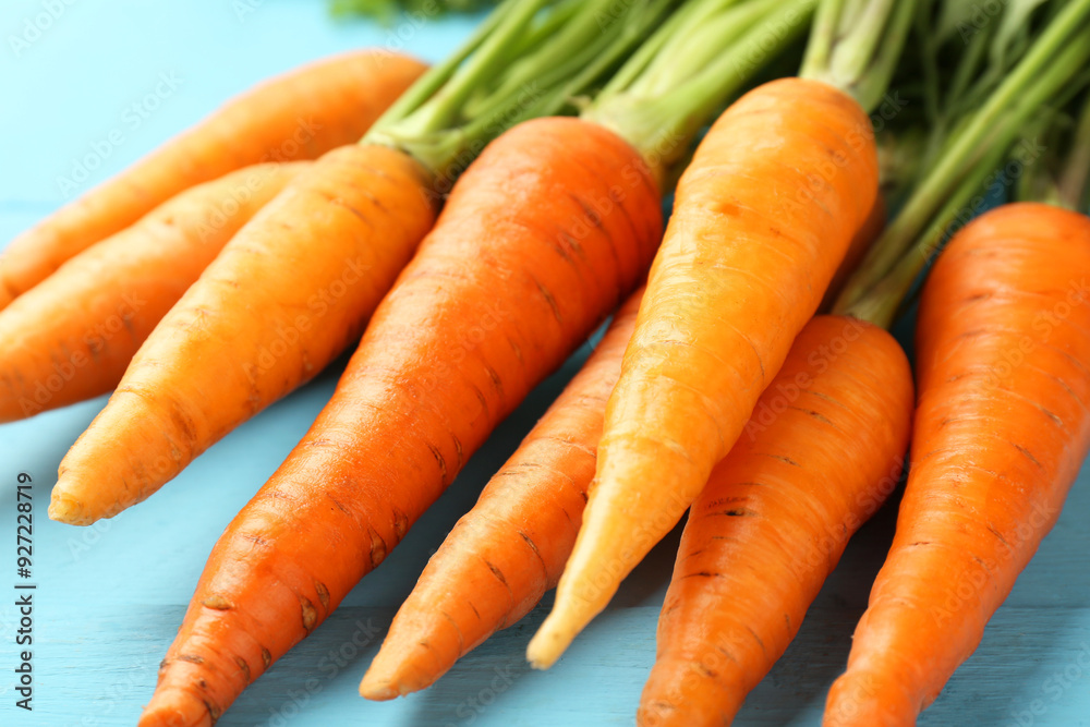 Tasty ripe juicy carrots on light blue wooden table, closeup Tasty ripe juicy carrots on light blue wooden table, closeup