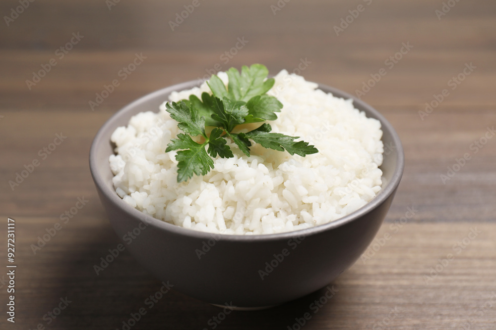 Bowl of delicious boiled rice with parsley on wooden table, closeup Bowl of delicious boiled rice with parsley on wooden table, closeup