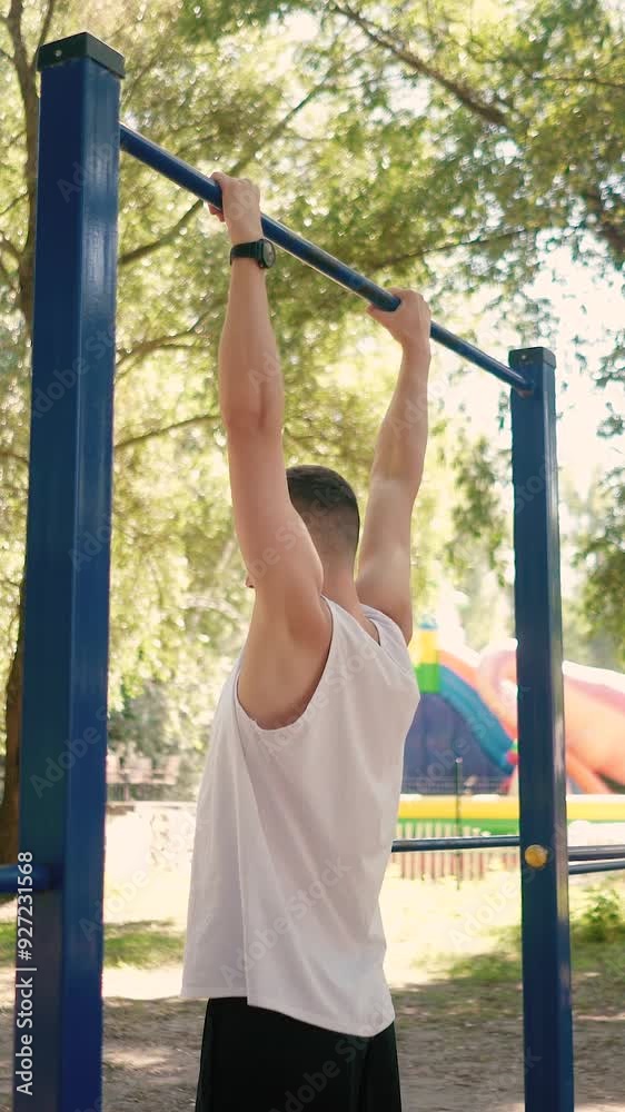 Handsome pumped up young male bodybuilder doing exercises on horizontal bar and parallel bars outdoors on the street. Beautiful male body shapes, beauty and health, training and motivation Handsome pumped up young male bodybuilder doing exercises on horizontal bar and parallel bars outdoors on the street. Beautiful male body shapes, beauty and health, training and motivation