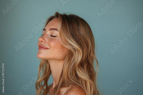 A close up of a woman's face with her eyes closed and long blond hair