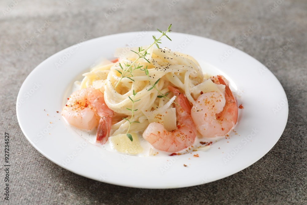 Delicious pasta with shrimps and cheese on grey table, closeup Delicious pasta with shrimps and cheese on grey table, closeup