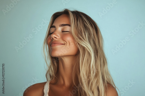 A close up of a woman's face with her eyes closed and long blond hair