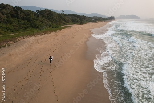 Surfer with board on dusk walking at Florianopolis, Brazil. photo