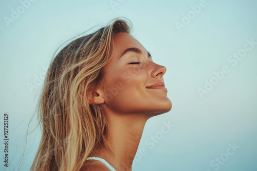 A close up of a woman's face with her eyes closed and long blond hair