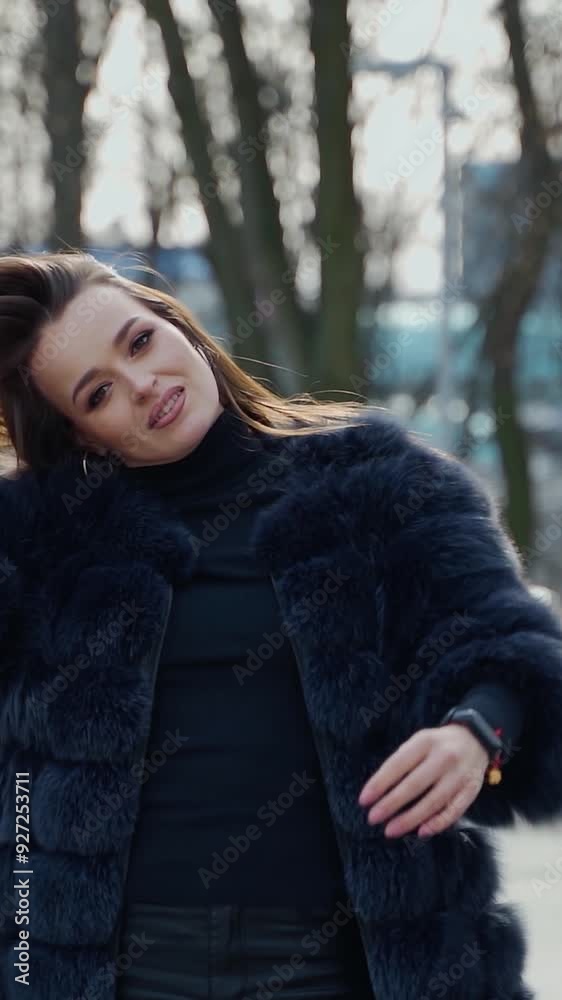 Portrait of a sexy girl outdoors. Attractive woman in a luxury fur coat in the park. Beautiful young model on the city street background. Slow motion. Vertical video Portrait of a sexy girl outdoors. Attractive woman in a luxury fur coat in the park. Beautiful young model on the city street background. Slow motion. Vertical video