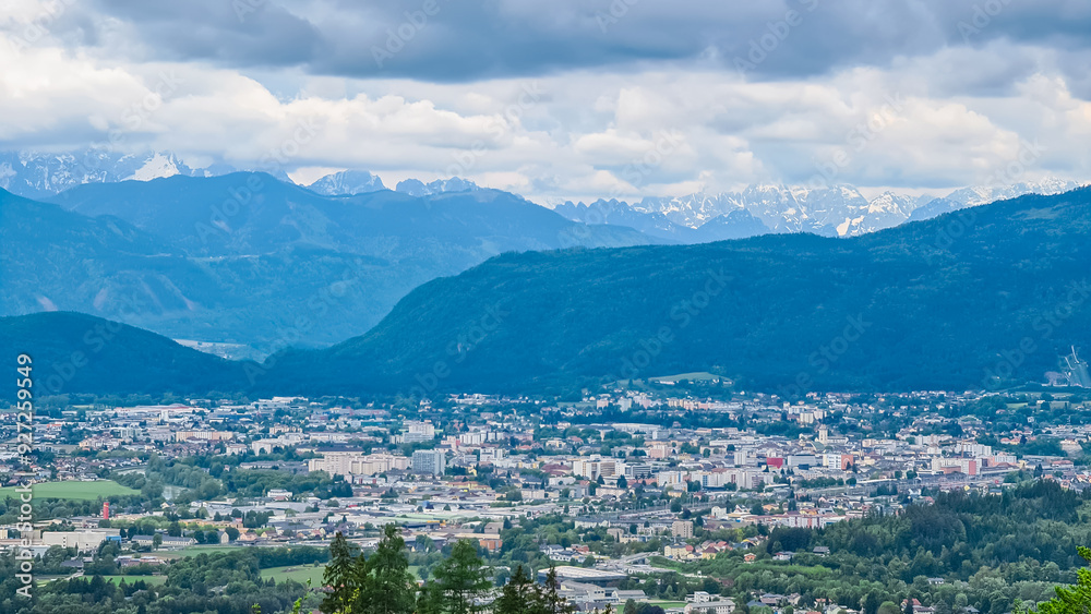 Panoramic aerial view of the city of Villach surrounded by majestic mountain ranges of Julian Alps and Karawanks, Carinthia, Austria, Europe. Idyllic forest walk near the Landskron Castle. Cityscape. Panoramic aerial view of the city of Villach surrounded by majestic mountain ranges of Julian Alps and Karawanks, Carinthia, Austria, Europe. Idyllic forest walk near the Landskron Castle. Cityscape.
