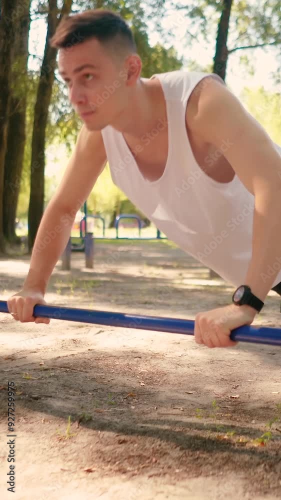 Handsome pumped up young male bodybuilder doing exercises on horizontal bar and parallel bars outdoors on the street. Beautiful male body shapes, beauty and health, training and motivation Handsome pumped up young male bodybuilder doing exercises on horizontal bar and parallel bars outdoors on the street. Beautiful male body shapes, beauty and health, training and motivation