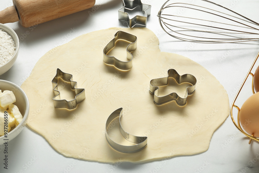 Raw dough and cookie cutters on white table, closeup Raw dough and cookie cutters on white table, closeup