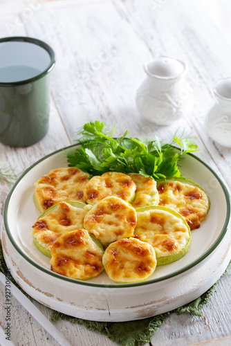 Baked zucchini with cheese, garlic on a white wooden background,selective focus.