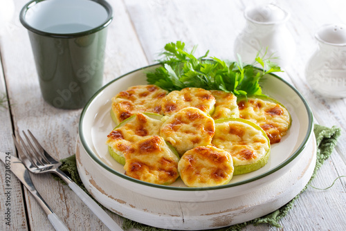 Baked zucchini with cheese, garlic on a white wooden background,selective focus.