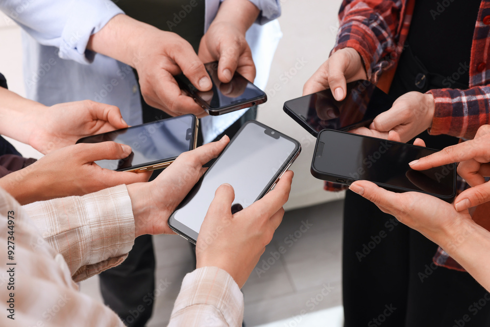 People holding smartphones with blank screens indoors, closeup People holding smartphones with blank screens indoors, closeup
