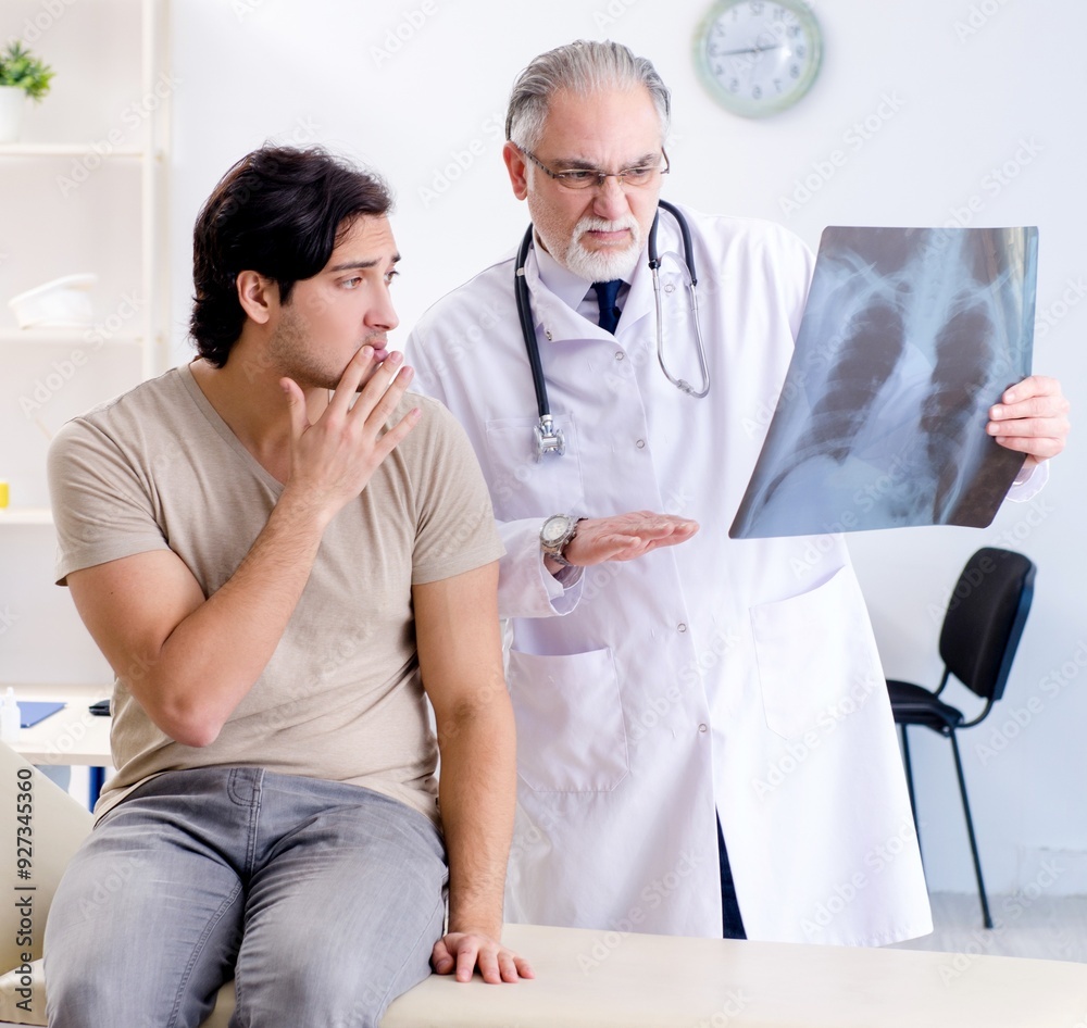 Fototapeta premium Young man visiting old male doctor radiologist