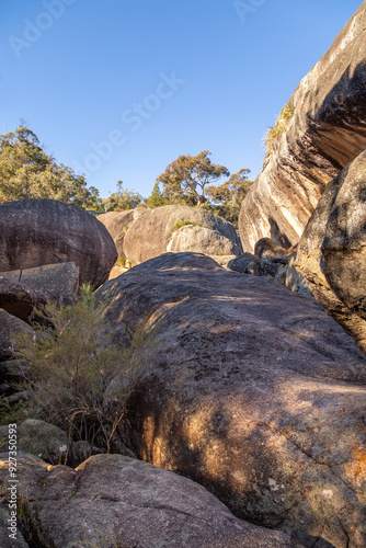 A jumble of granite boulders and the eroded granite dome with some trees and blue sky at Underground creek in Girraween National Park in the granite belt in Queensland, Australia. photo