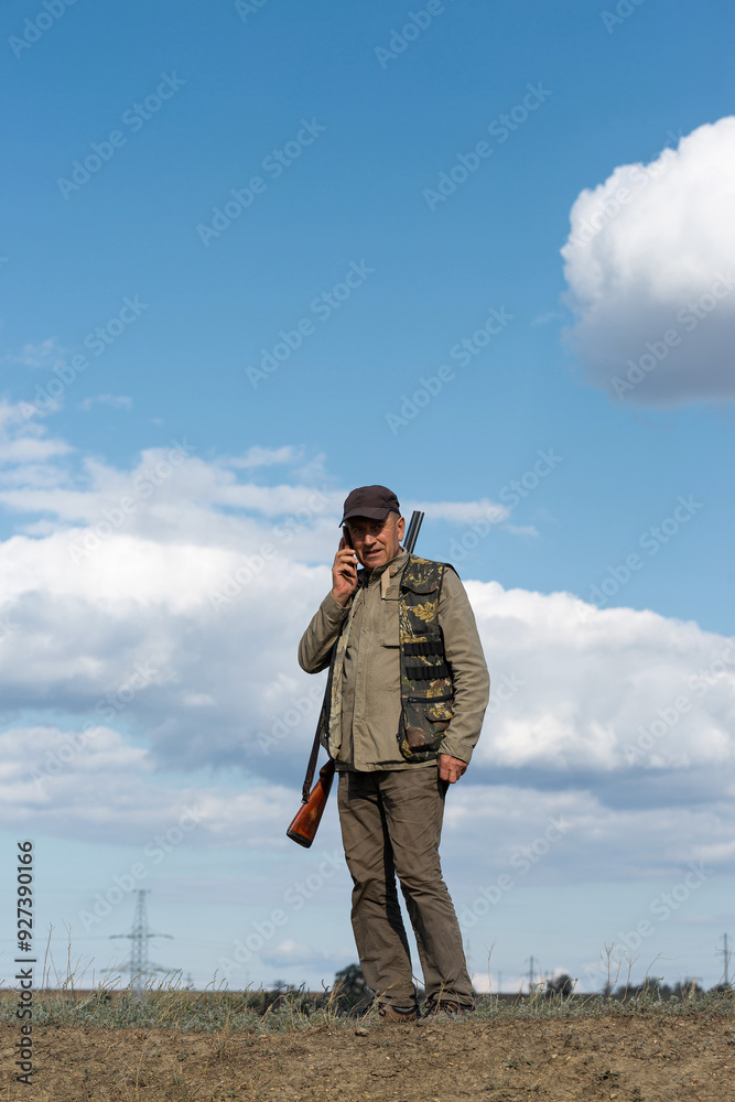 Mature man hunter with gun while walking on field. Mature man hunter with gun while walking on field.