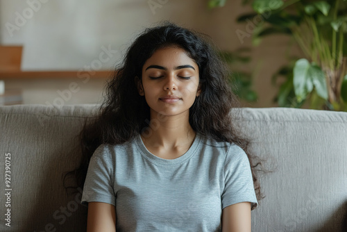 Indian Woman in Meditation Pose on a Couch: Close-Up of Deep Breathing Yoga Practice for Relaxation and Mental Health at Home