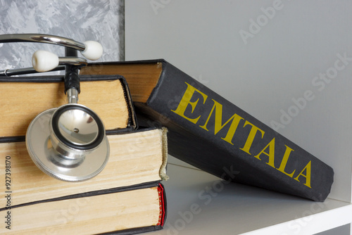 Stethoscope and a book titled Emergency Medical Treatment and Labor Act EMTALA. Medical compliance and emergency care.