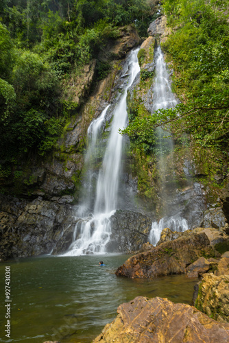 Waterfall in deep tropical rainforest with green rainy tree