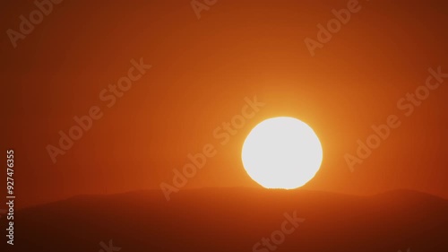 Zoom in to Extreme Closeup of Sun Rising Over a Hill into a Red Sky 4K Timelapse