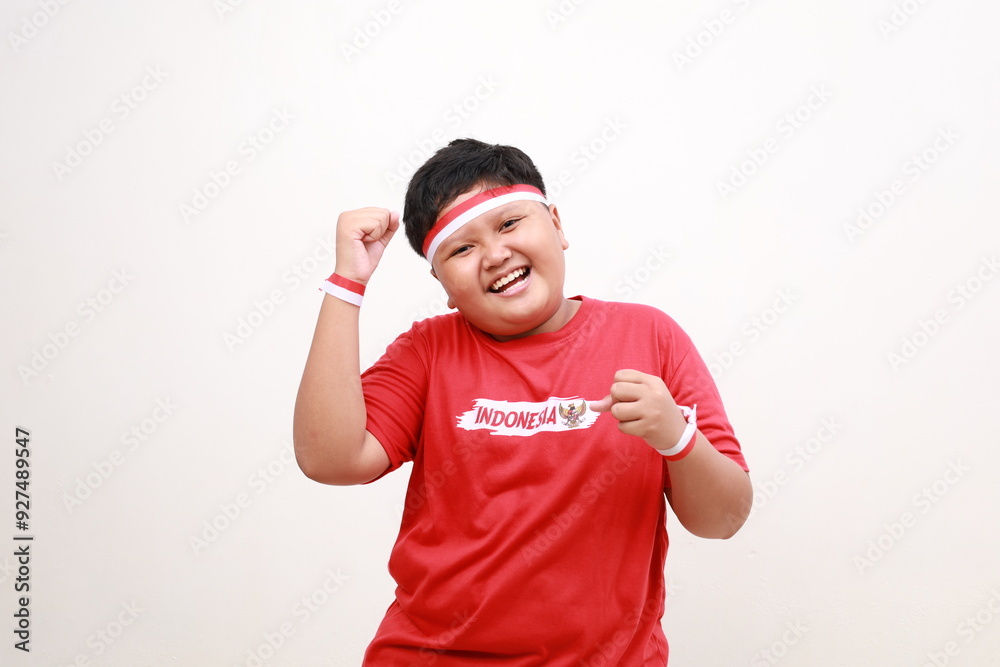 Naklejka premium Young Asia boy with positive expression, joyful and exciting, dressed in casual cloth and red white ribbon. Happy adorable glad boy rejoices success. Independence day concept
