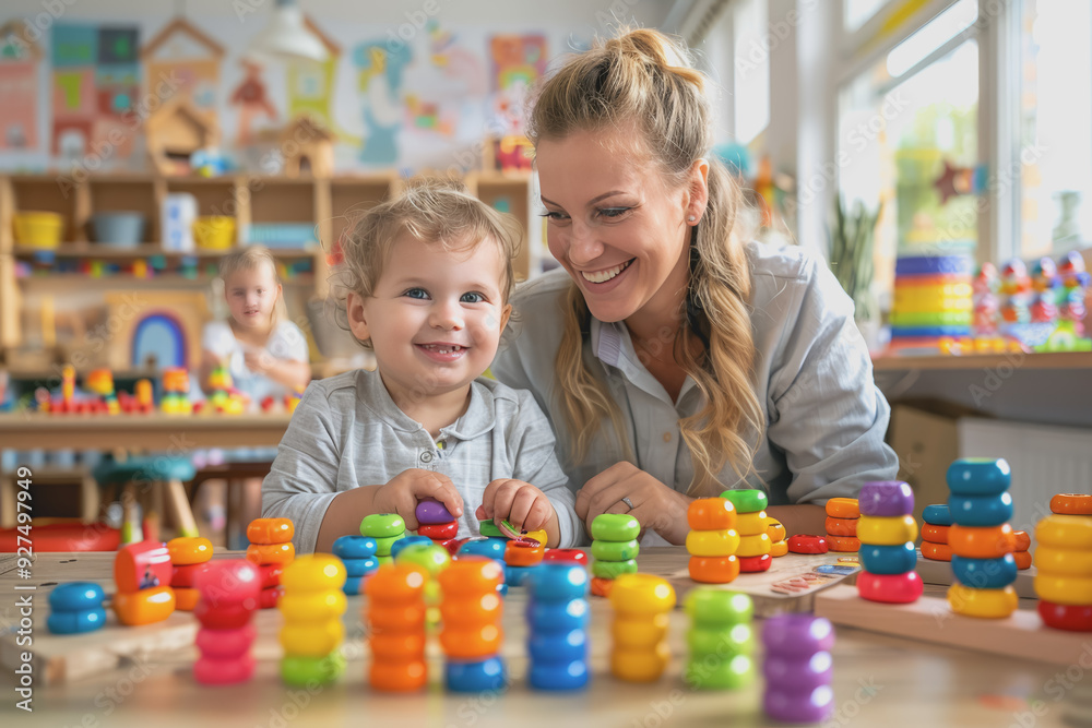 Teacher and toddler playing with maths puzzle game sitting on the table at kindergarten. Teacher and toddler playing with maths puzzle game sitting on the table at kindergarten.