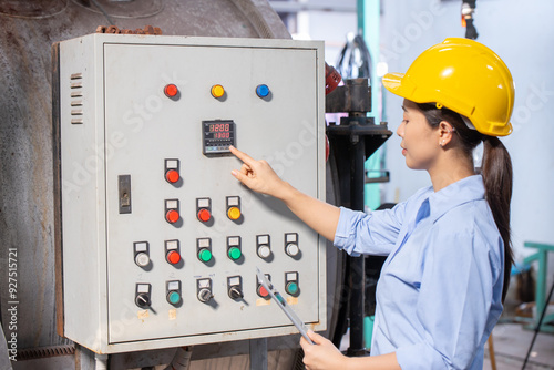 Factory engineer operate control machine pressing control panel monitor temperature of water boiler switch in factory.