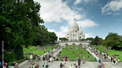 sacre coeur cathedral in paris with tourists on the steps