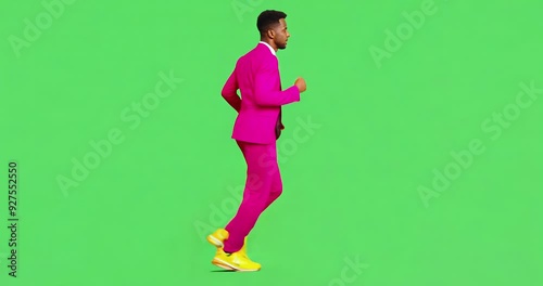  Man in a pink suit walks cheerfully on green background. photo