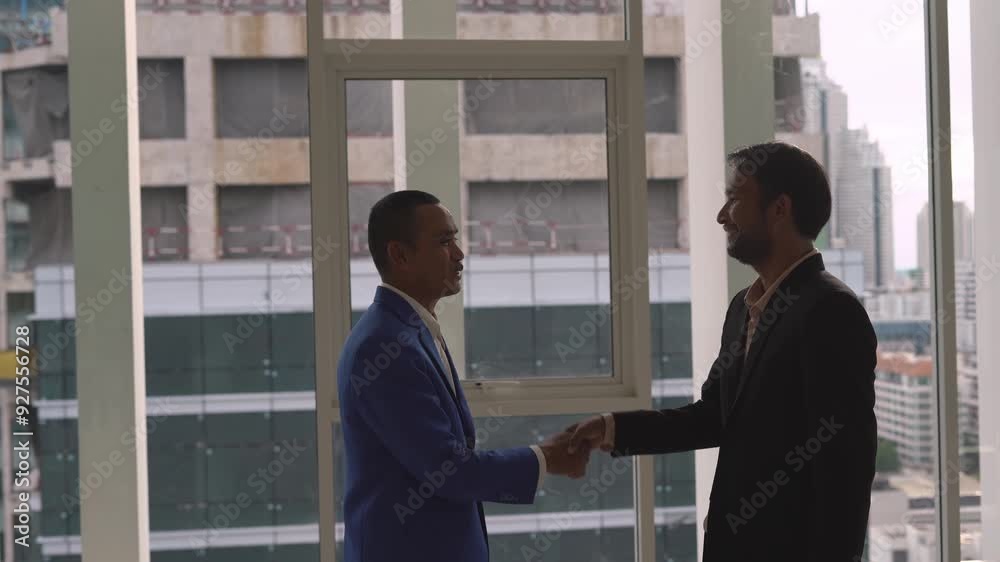 Two businessmen shake hands in an office, symbolizing a successful agreement and partnership in a corporate setting. Two businessmen shake hands in an office, symbolizing a successful agreement and partnership in a corporate setting.