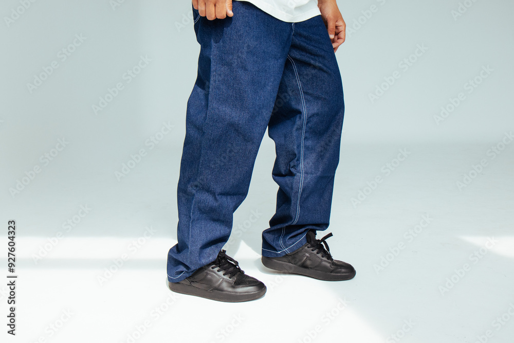 Fashion forward people concept with male model in well-fitted dark blue regular jeans. The design showcases comfort and style in everyday dark denim wear.