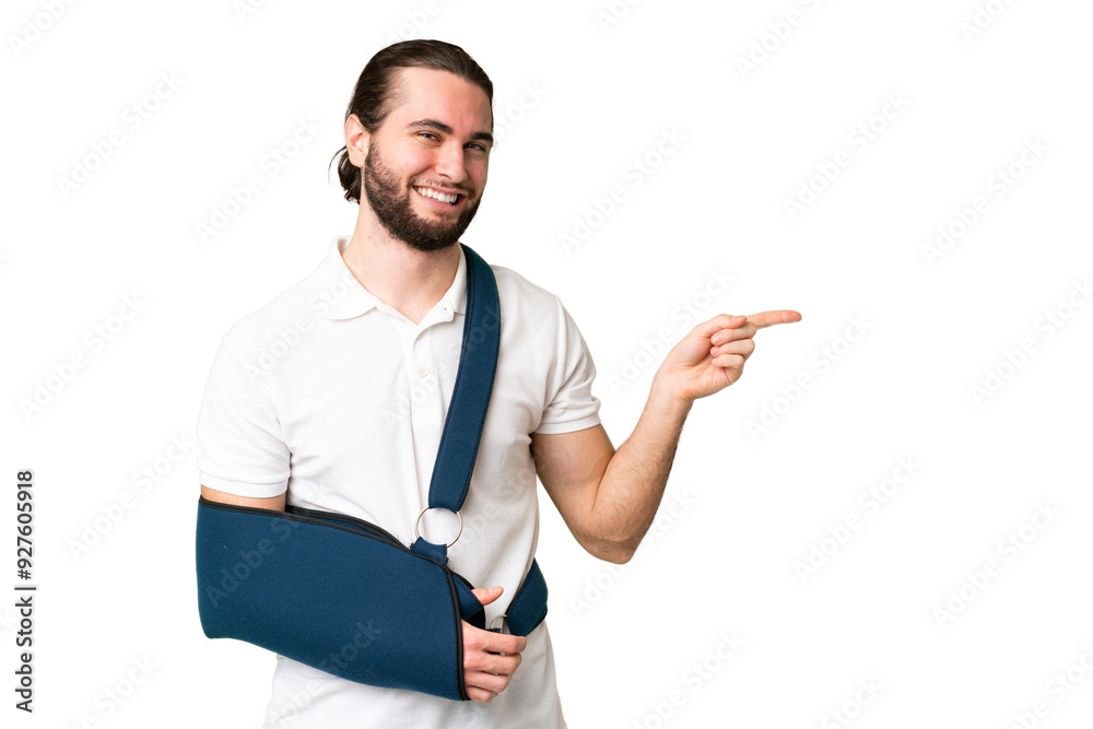 Young handsome man with broken arm and wearing a sling over isolated chroma key background pointing finger to the side Young handsome man with broken arm and wearing a sling over isolated chroma key background pointing finger to the side