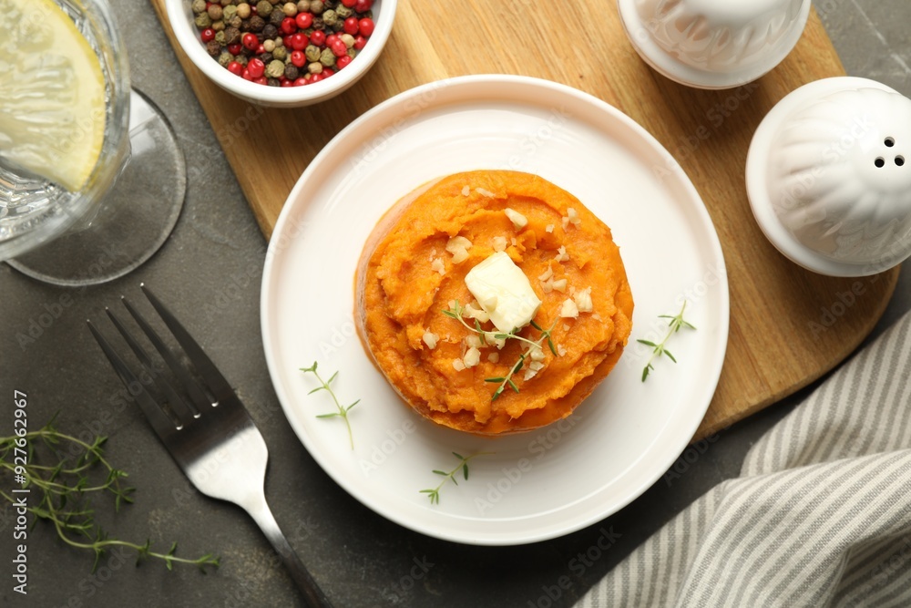 Tasty mashed sweet potato, butter, thyme and walnuts served on grey textured table, flat lay Tasty mashed sweet potato, butter, thyme and walnuts served on grey textured table, flat lay